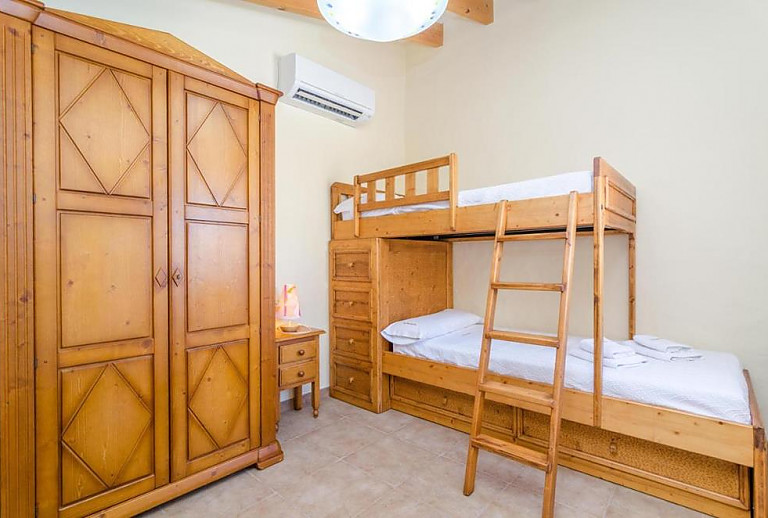 Schlafzimmer mit Doppelstockbett und Kleiderschrank