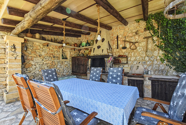 Terrasse mit Esstisch und Sommerküche